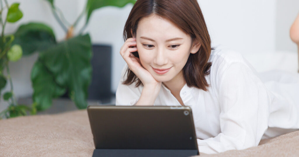 A woman is watching a video on a tablet