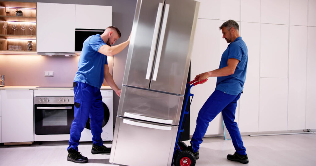 a man carries a refrigerator